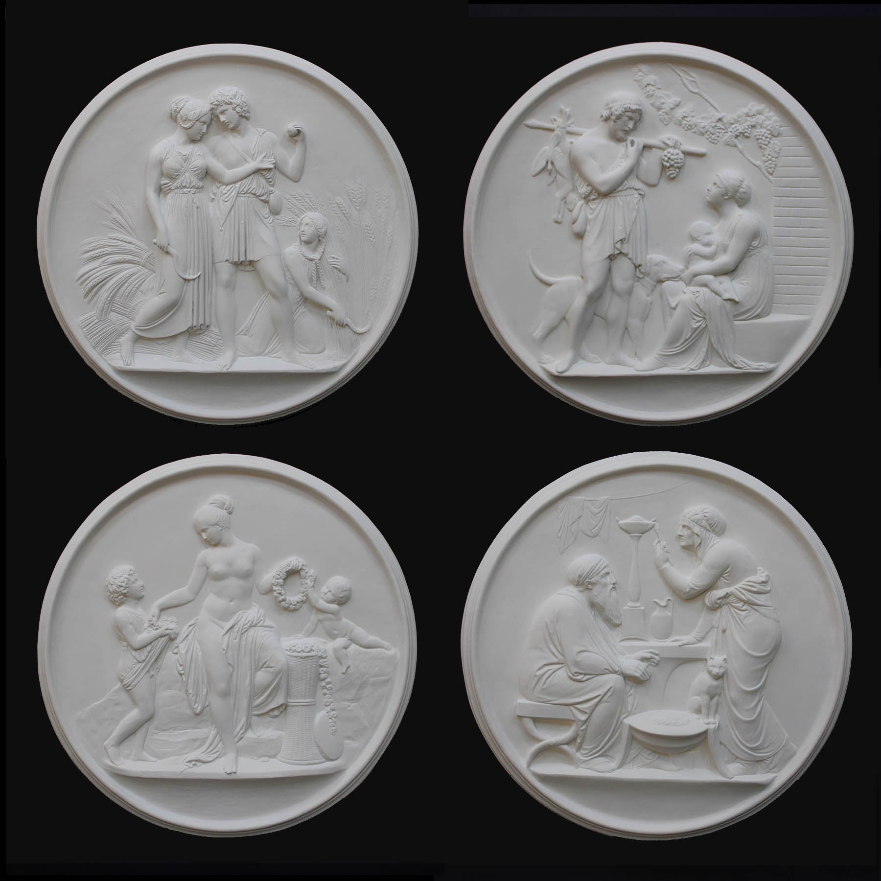 photo of four white plaster cast relief sculptures of male and female figures, children, cats, and dogs figuratively depicting the four seasons against black background