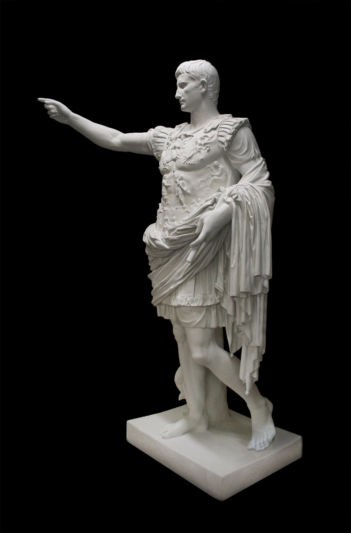 photo of white plaster cast sculpture of a man with armor and robes standing in contrapposto with his right arm raised, namely Augustus Caesar, against a black background