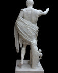 photo of reverse of white plaster cast sculpture of a man with armor and robes standing in contrapposto with his right arm raised, namely Augustus Caesar, against a black background