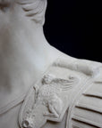 detail photo of armor from white plaster cast sculpture of a man's torso, namely Augustus Caesar, against a black background