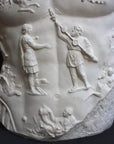 detail photo of armor from white plaster cast sculpture of a man's torso, namely Augustus Caesar, against a black background