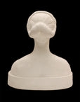 back view photo of white plaster cast sculpture of female bust cropped at shoulders with decorative base against black background