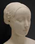 detail photo of white plaster cast sculpture of female bust cropped at shoulders with decorative base against black background