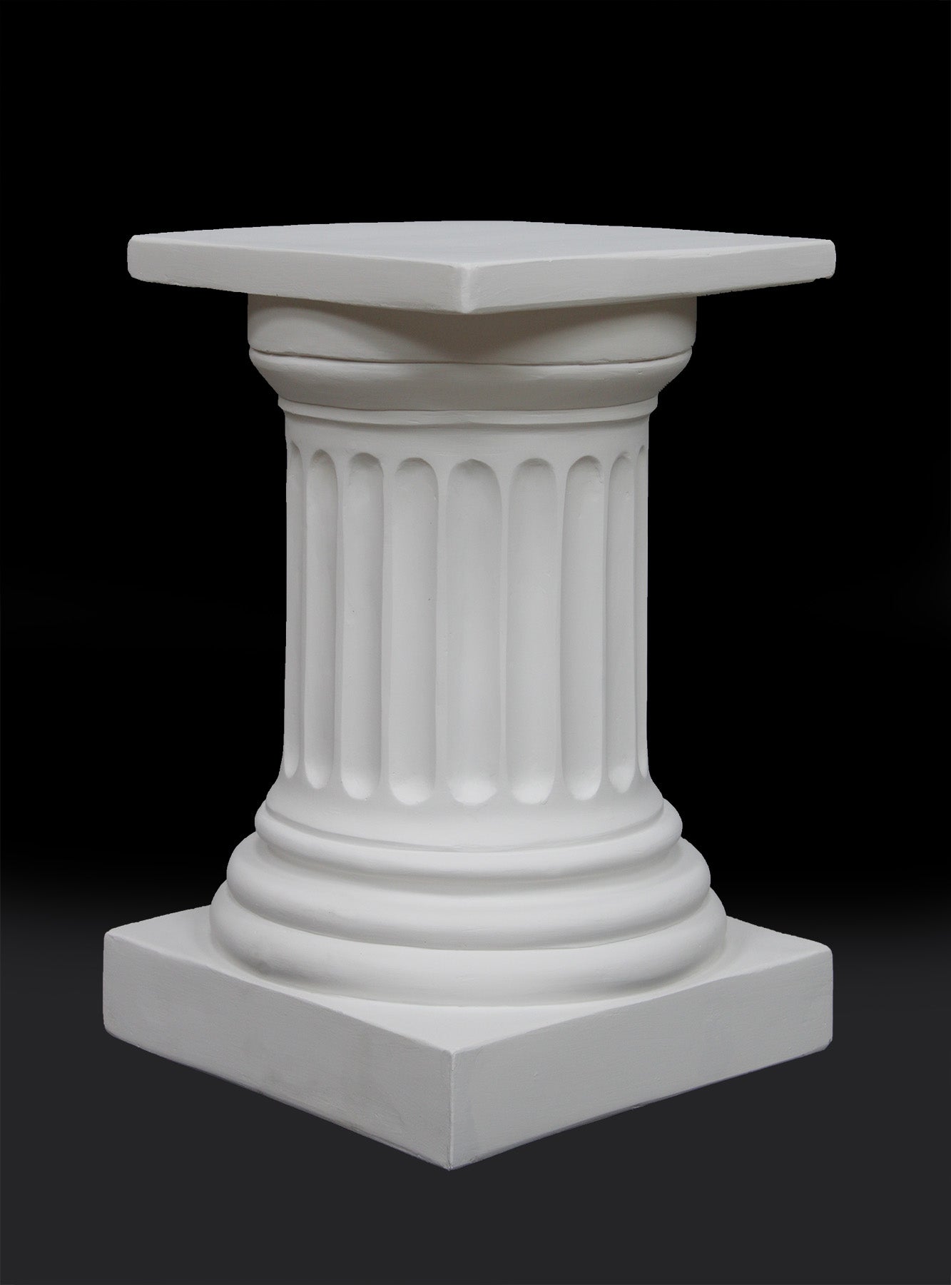 photo of short white plaster cast pedestal in the Doric style with a fluted column against a black background