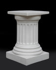 photo of short white plaster cast pedestal in the Doric style with a fluted column against a black background