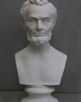 photo with gray background of plaster cast bust sculpture of man with beard, namely Lincoln