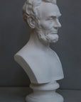 photo with gray background of plaster cast bust sculpture of man with beard, namely Lincoln