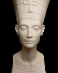 photo of plaster cast sculpture of bust of Nefertiti with crown and decorative collar on a decorative base with a black background