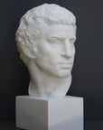 Photo of plaster cast sculpture of man's head on a grey background