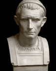 photo with black background of plaster cast bust sculpture of a man, namely Antiochus III, with headband and clothing on the square bust