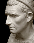 closeup photo with black background of plaster cast bust sculpture of a man, namely Antiochus III, with headband and clothing on the square bust