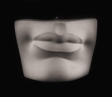 Photo of plaster cast sculpture of mouth and chin from Michelangelo&#39;s David statue on a black background