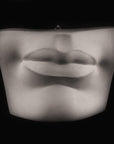 Photo of plaster cast sculpture of mouth and chin from Michelangelo's David statue on a black background