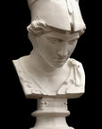 photo of plaster cast sculpture bust of female head, namely the goddess Minerva, with a helmet and looking down and placed on a pedestal with black background