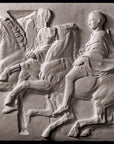 photo of off-white plaster cast relief sculpture of two men on horseback from Parthenon against black background