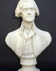 Photo of plaster cast bust sculpture of man with coat and neckerchief, namely Thomas Jefferson, with dark gray background