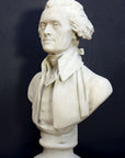 Photo of plaster cast bust sculpture of man with coat and neckerchief, namely Thomas Jefferson, with dark gray background