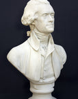 Photo of plaster cast bust sculpture of man with coat and neckerchief, namely Thomas Jefferson, with dark gray background