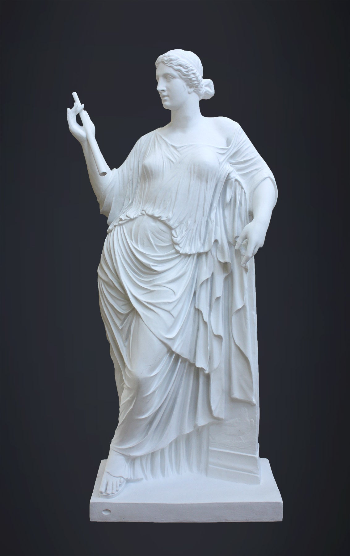 photo of plaster cast sculpture of female figure in robes leaning on podium