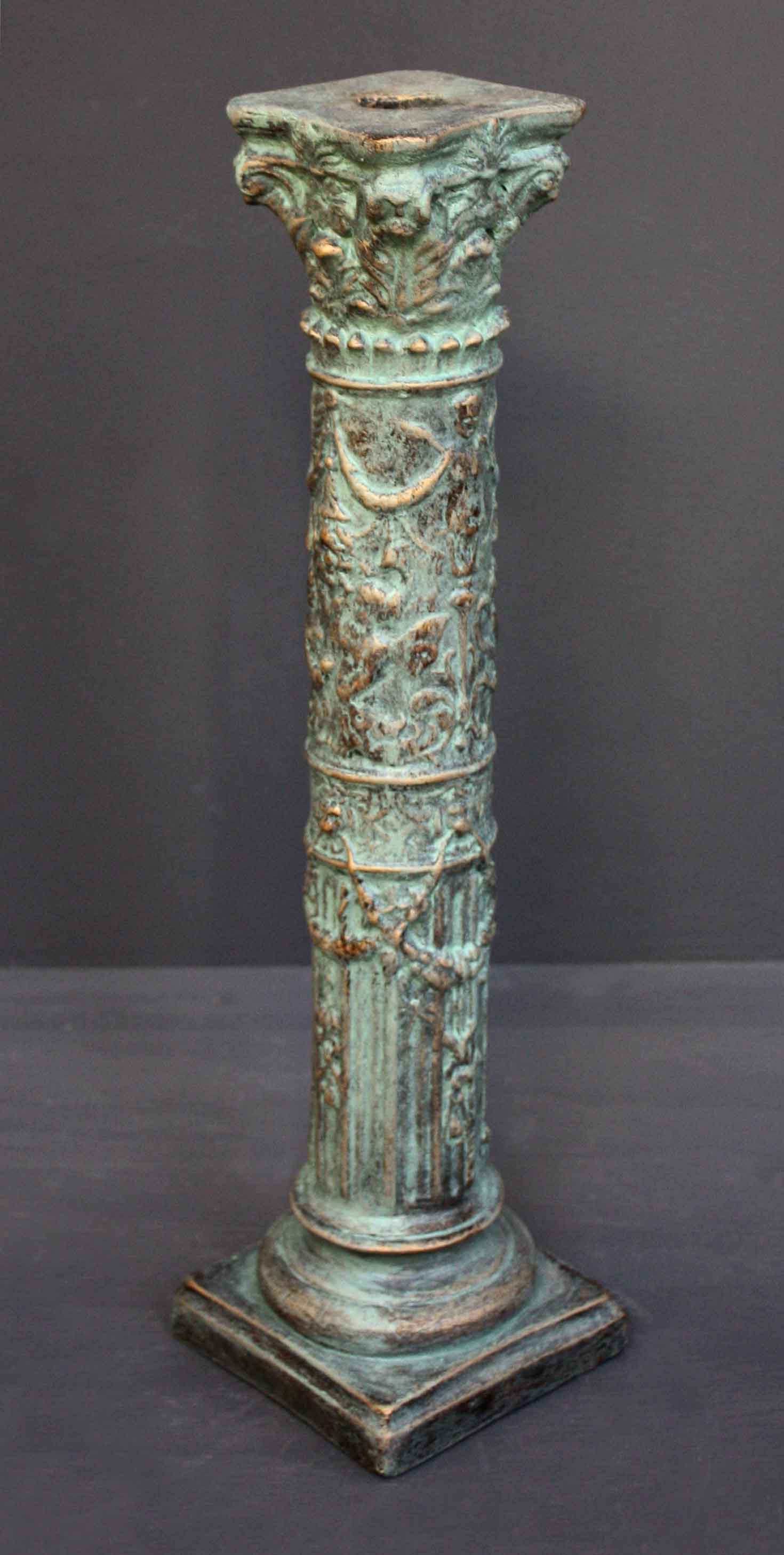 photo of plaster cast of ornamental verdigris color candlestick with gray background