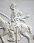 closeup photo of plaster cast relief sculpture of man riding horse in profile