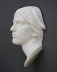 photo with gray background of plaster cast sculpture of Joan of Arc's face and portion of kerchief on head