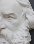 closeup photo of plaster cast of man's head, namely Longfellow, with long hair and curly beard on gray background