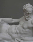 photo of plaster cast of reclining male nude with a gray background