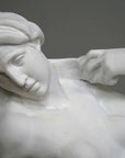 closeup photo of plaster cast of reclining female nude with a gray background