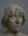 closeup photo of plaster cast bust of man with high-neck shirt and shoulder-length hair with gray background