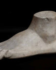 Photo of plaster cast sculpture of blocked foot on a black background