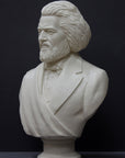 photo of white plaster cast sculpture of bust of Frederick Douglass with beard and in suit coat with toga over one shoulder on dark gray background