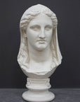 photo of white plaster cast of ancient sculpture of female head with curls and wrap, namely Demeter, on socle base on dark gray background