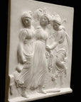 Photo with black background of plaster cast sculpture relief of females dancing