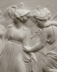 Photo with black background of plaster cast sculpture relief of females dancing