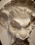 Photo of a cropped plaster sculpture of a Faun Head on a black background