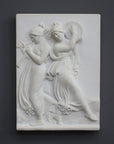 Photo with black background of plaster cast sculpture relief of females playing instruments