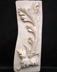 photo of off-white plaster cast relief sculpture of acanthus leaf against black background