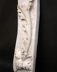 photo of off-white plaster cast relief sculpture of acanthus leaf against black background