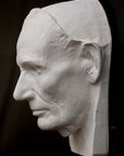 Photo of plaster cast sculpture of life mask of Abraham Lincoln from a side view on a black background