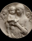 photo of plaster cast sculpture relief of the Madonna holding baby Jesus and angels in the background on a black background