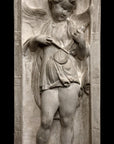 photo of yellowed plaster cast relief sculpture with angel playing a lyre on a black background