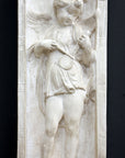 photo of plaster cast relief sculpture with angel playing a lyre on a dark gray background