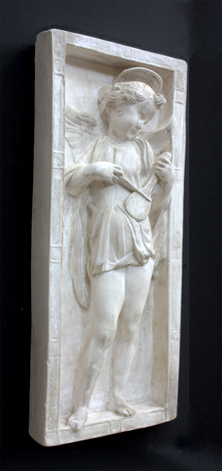 photo of plaster cast relief sculpture with angel playing a lyre on a dark gray background