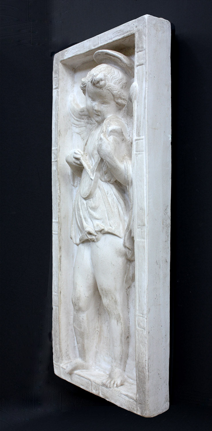 photo of plaster cast relief sculpture with angel playing a lyre on a dark gray background