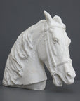 photo of plaster cast of horse head with bridle on a gray background