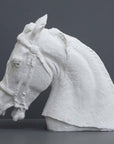 photo of plaster cast of horse head with bridle on a gray background