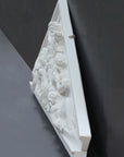 photo of white triangular plaster cast sculpture relief of the god Zeus in the center and the Giants around him on a gray background