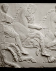 photo of off-white plaster cast relief sculpture of three men on horseback from Parthenon against black background