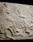 photo of off-white plaster cast relief sculpture of three men on horseback from Parthenon against black background